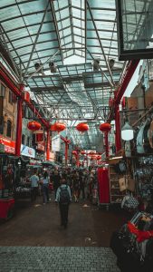 Photo of chinese urban market aisle with colored displays and red lanterns with different stores selling obvious cheap stuff